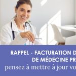 Médecin du travail souriante, assise à un bureau devant un ordinateur portable et tenant sa paire de lunettes dans la main.