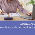 Homme assis à un bureau devant un ordinateur portable, deux tas de documents et une calculatrice.